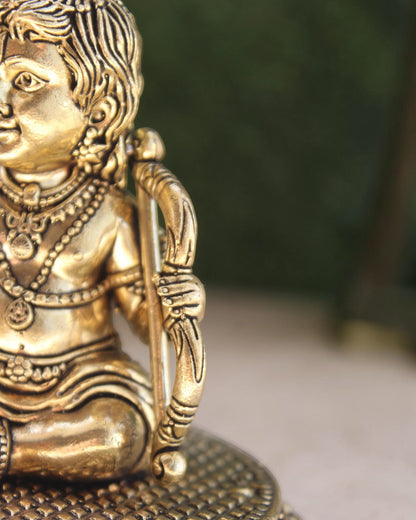 Rigvedaa	rade	rade Brass Ram Lalla idol, 4-inch Bal Ram Murti for puja, detailed with ornate jewelry and a bow.
