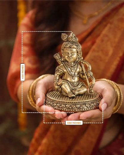 Rigvedaa™ 4-inch brass Ram Lalla idol featuring intricate Bal Ram details held in hands for home temple worship.