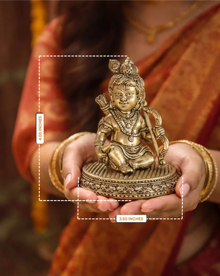 Rigvedaa™ 4-inch brass Ram Lalla idol featuring intricate Bal Ram details held in hands for home temple worship.