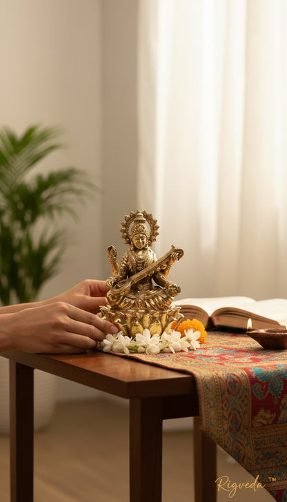 Rigvedaa brass Saraswati Mata idol seated on lotus, holding veena and scriptures. Detailed sculpture for wisdom and creativity.