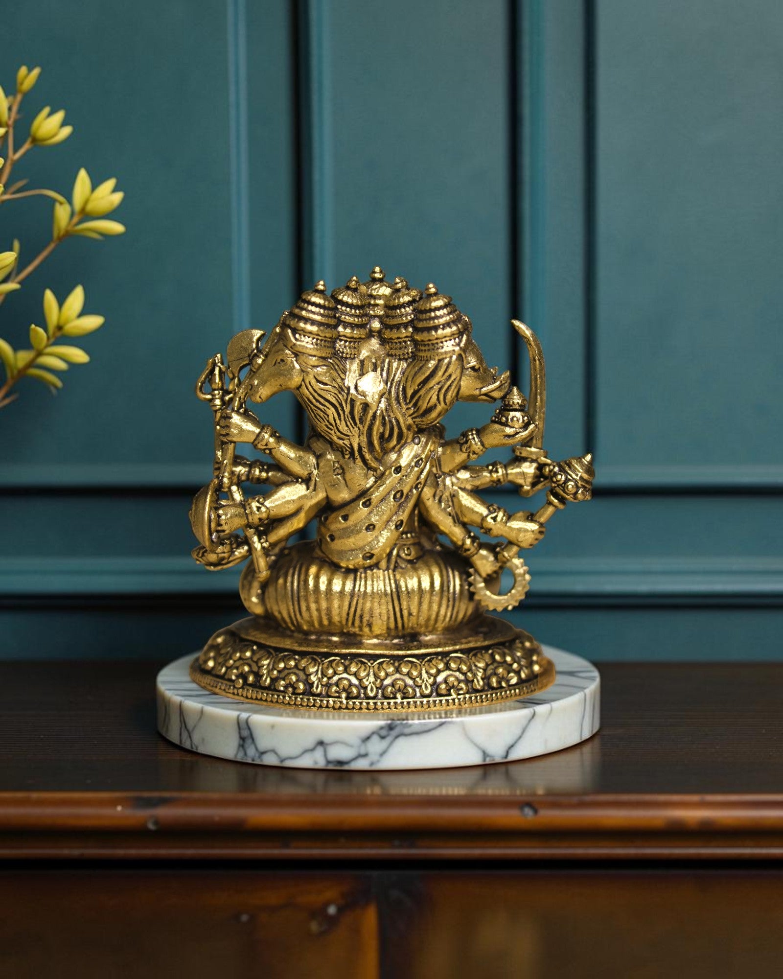 Rigvedaa™ Brass Sitting Panchmukhi Hanuman Statue with five faces and multiple arms holding weapons, on a marble base.