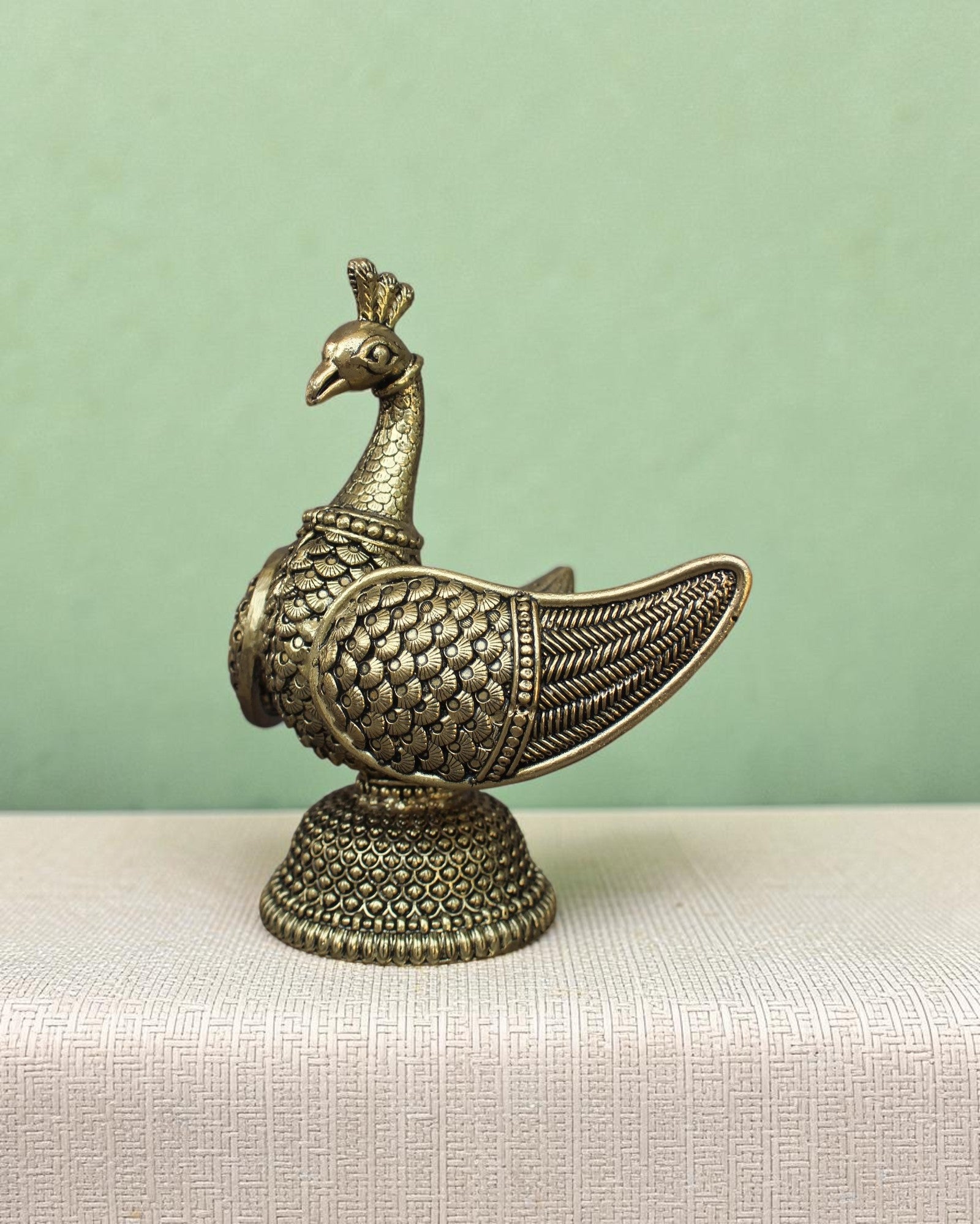 Rigvedaa™ handcrafted brass swan statue with intricately carved fan wings and detailed base. Golden patina finish.