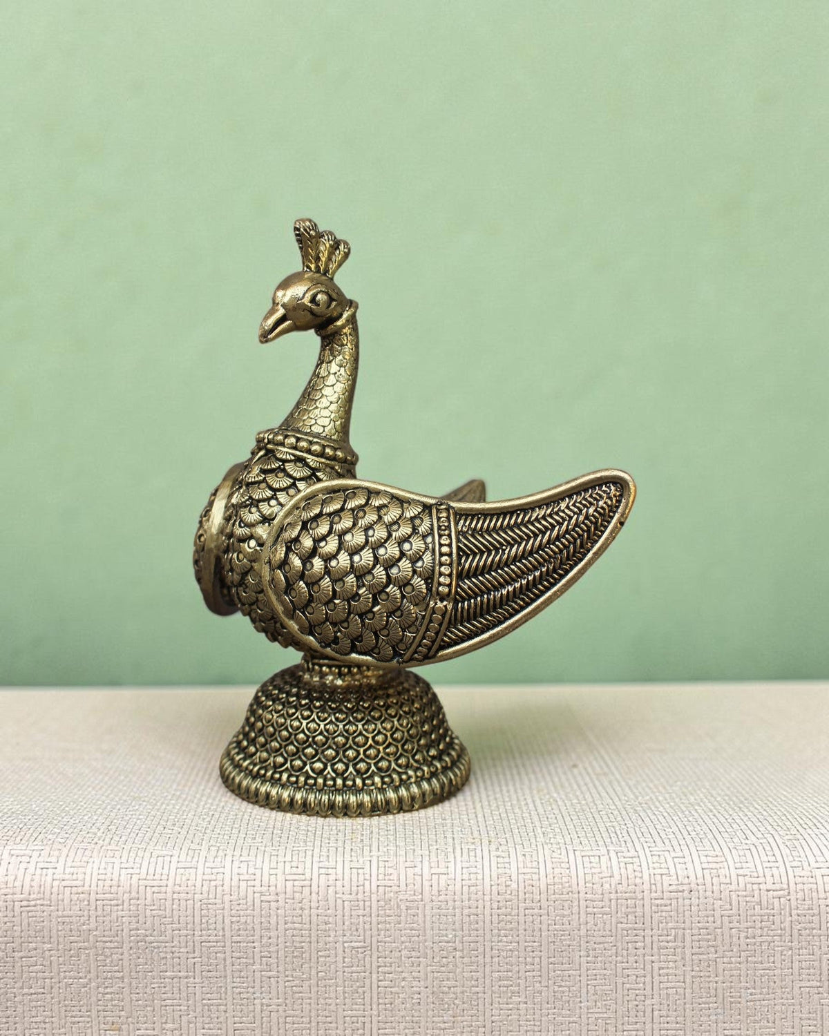 Rigvedaa™ handcrafted brass swan statue with intricately carved fan wings and detailed base. Golden patina finish.