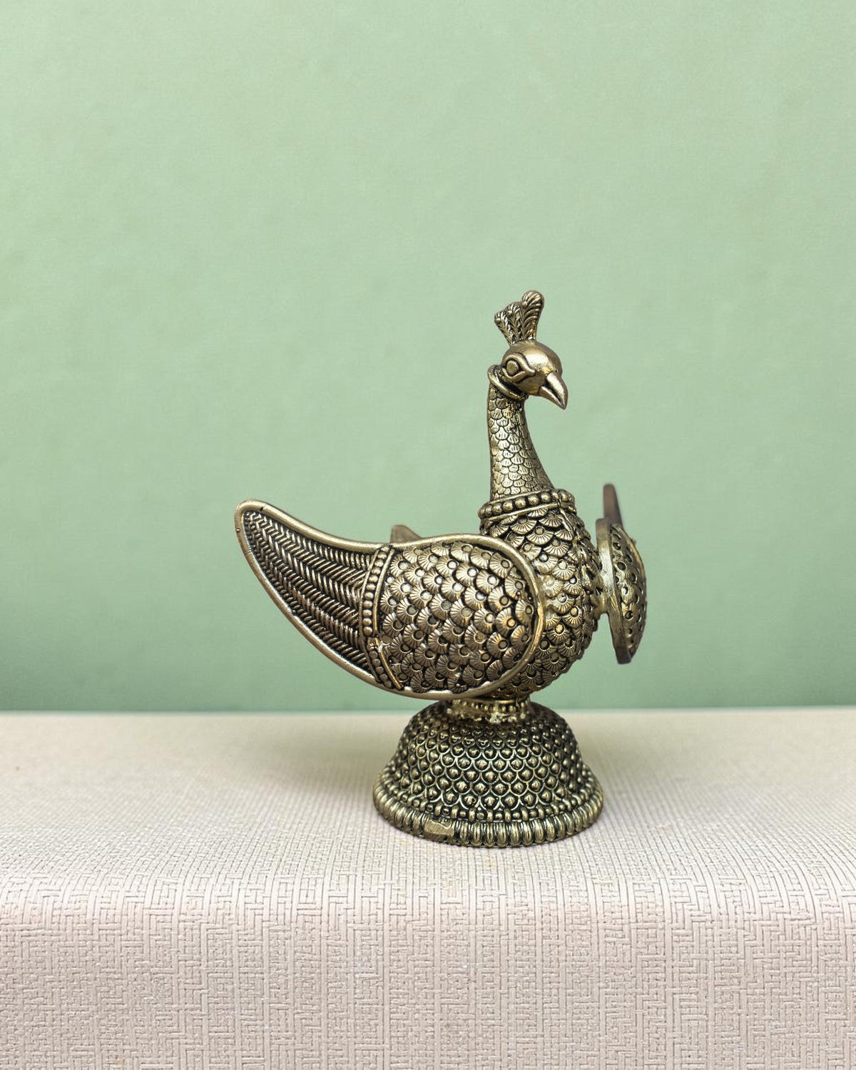 Rigvedaa™ brass swan statue with intricately carved fan wings and textured base. Golden patina finish.