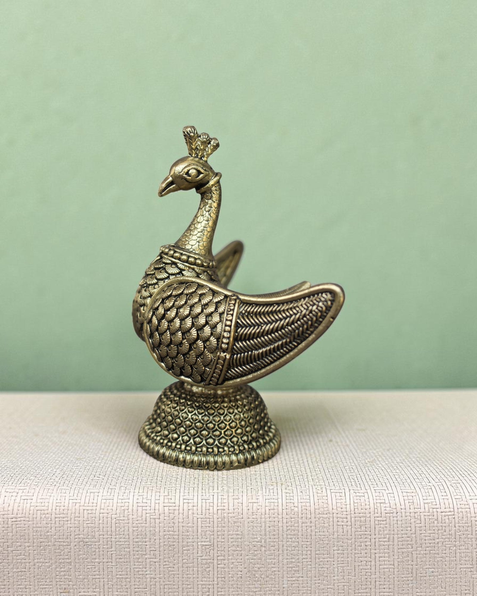 Rigvedaa™ handcrafted brass swan statue with carved fan wings and intricate base. Golden patina finish.