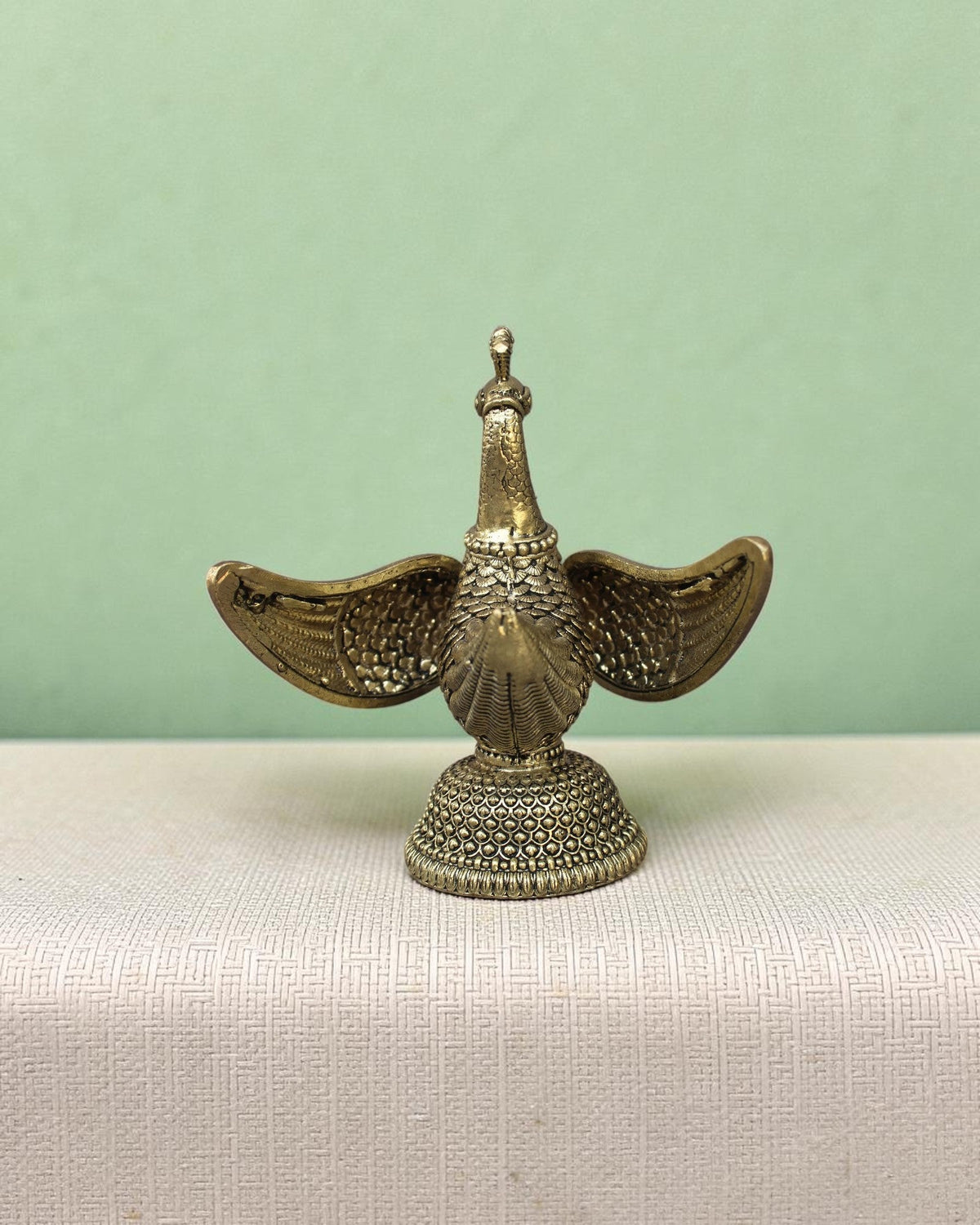 Rigvedaa™ handcrafted brass swan statue with carved fan wings and intricate base. Golden patina.