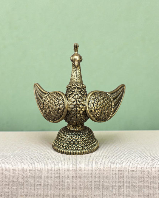 Rigvedaa™ brass swan statue with intricately carved fan wings and textured base. Golden patina finish.