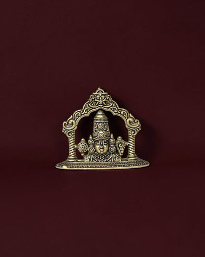 Rigvedaa™ brass Lord Venkateswara Tirupati Balaji face idol with intricate crown detailing on a dark background