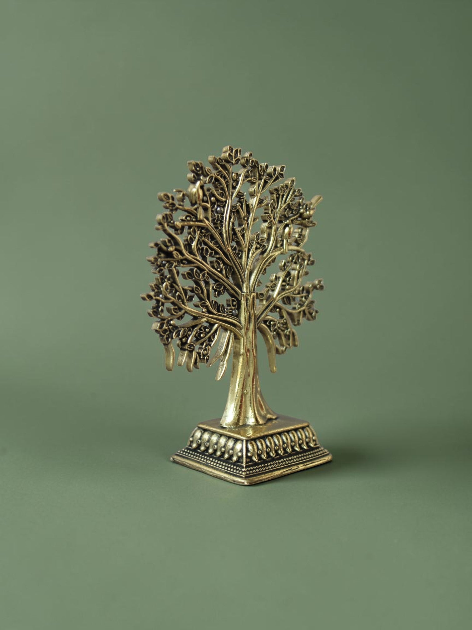 Rigvedaa™ brass Tree of Life tabletop sculpture with intricate branches, leaves, and bird accents on a square base.