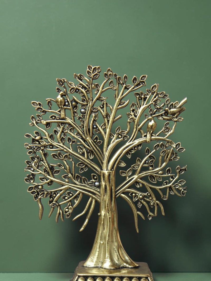 Rigvedaa™ brass Tree of Life tabletop sculpture with intricate branches, leaves, and bird accents on a green background