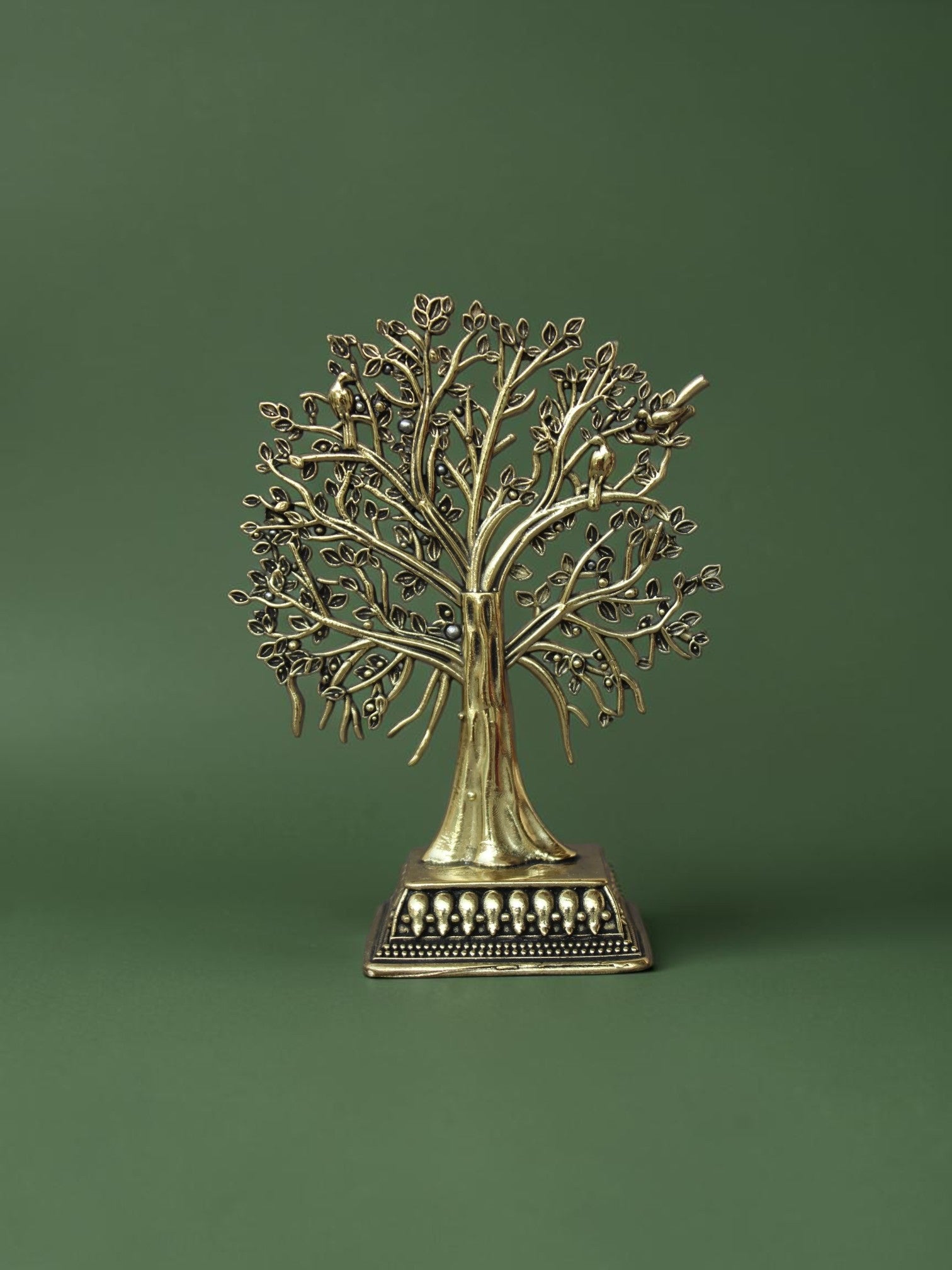 Rigvedaa™ brass Tree of Life tabletop sculpture with intricate branches, leaves, and bird accents on an ornate base.