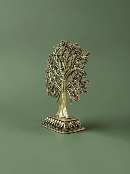 Rigvedaa™ brass Tree of Life tabletop sculpture with intricate branches, leaves, and bird accents on a green background