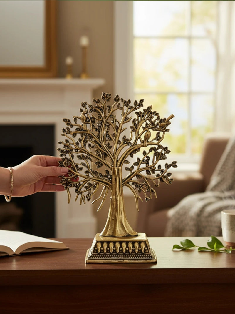 Rigvedaa™ brass Tree of Life tabletop sculpture with intricate branches, leaves, and bird accents on a wooden desk.
