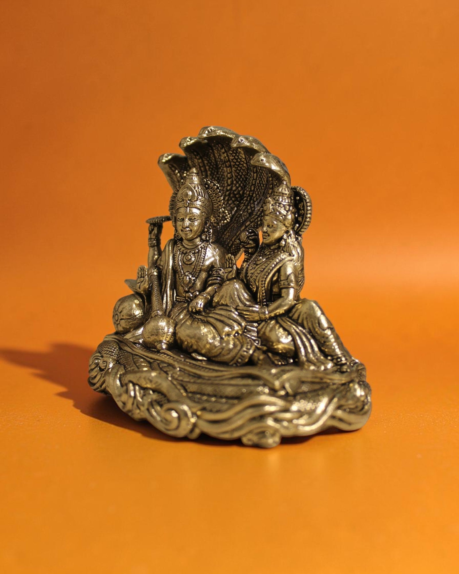 Rigvedaa™ Brass Vishnu Lakshmi Sheshnag statue, golden patina, intricate details, divine couple on serpent coils, for wealth and protection.