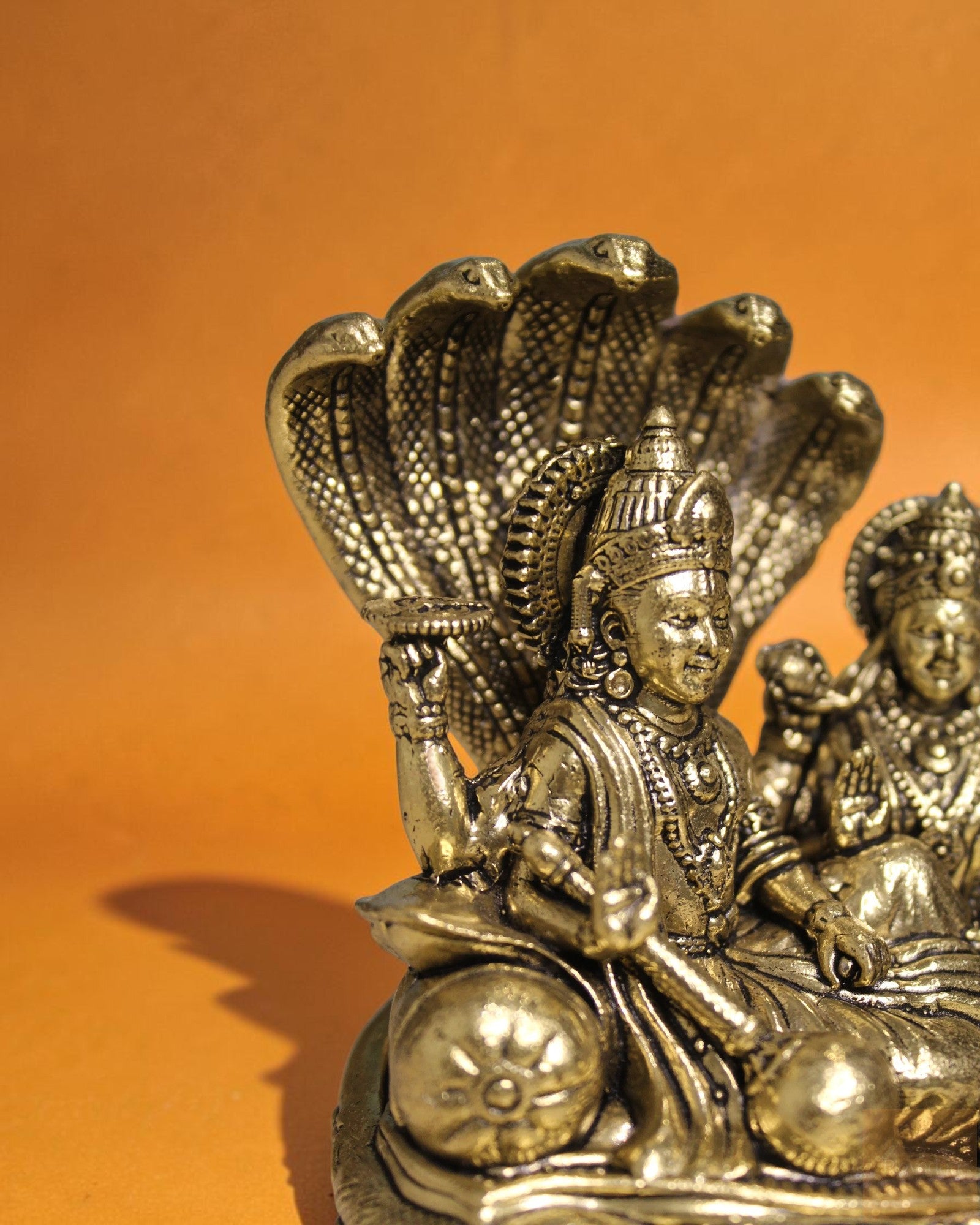 Rigvedaa™ Brass Vishnu Lakshmi Sheshnag statue, golden patina, intricate details, divine couple on serpent.