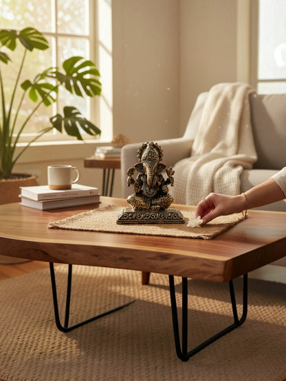 Rigvedaa™ decorative Lord Ganesha idol with antique gold finish, placed on a wooden table in a serene living room.