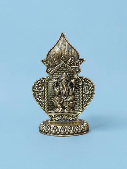 Rigvedaa™ antique gold Ganesha idol in an ornate arch frame with floral motifs and a lotus pedestal on a blue background
