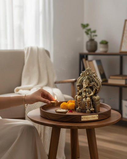 Rigvedaa™ antique brass Ganesha statue seated on an ornate throne, with intricate details and a serene expression.