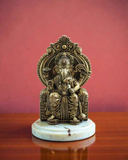 Rigvedaa™ Ornate antique brass Ganesha statue seated on an elaborate throne, detailed traditional Indian artistry.