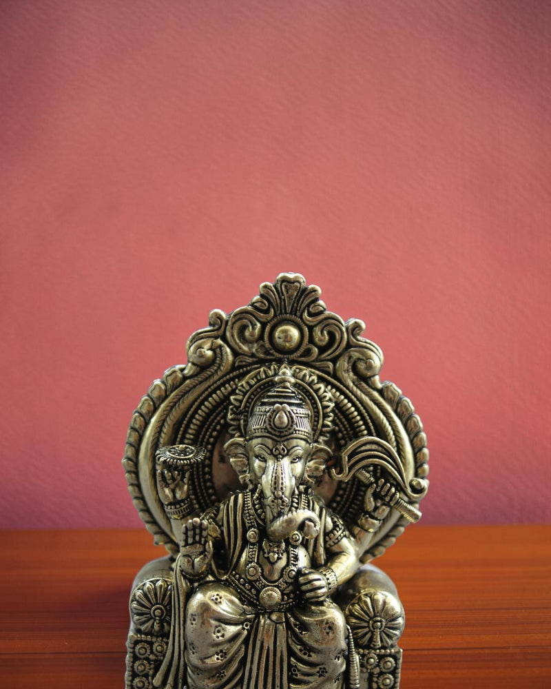 Rigvedaa™ Ornate antique brass Ganesha statue seated on a throne, detailed traditional Indian artistry.