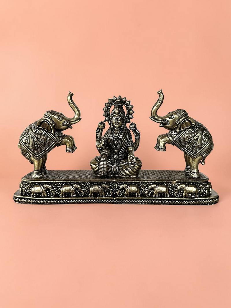 Rigvedaa™ antique bronze Goddess Lakshmi figurine flanked by two elephants on a decorative base for home decor.