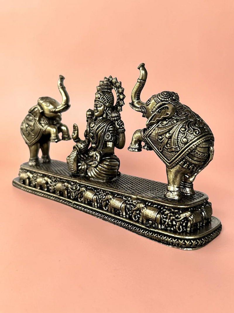 Rigvedaa™ Goddess Lakshmi figurine with two elephants in an antique bronze finish on a decorative textured base.