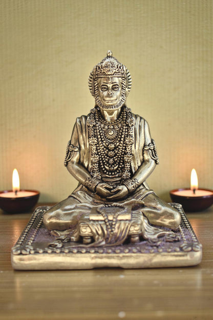 Rigvedaa brass idol of Lord Hanuman meditating in Ram Sadhna posture, adorned with necklaces, seated on a decorative base.