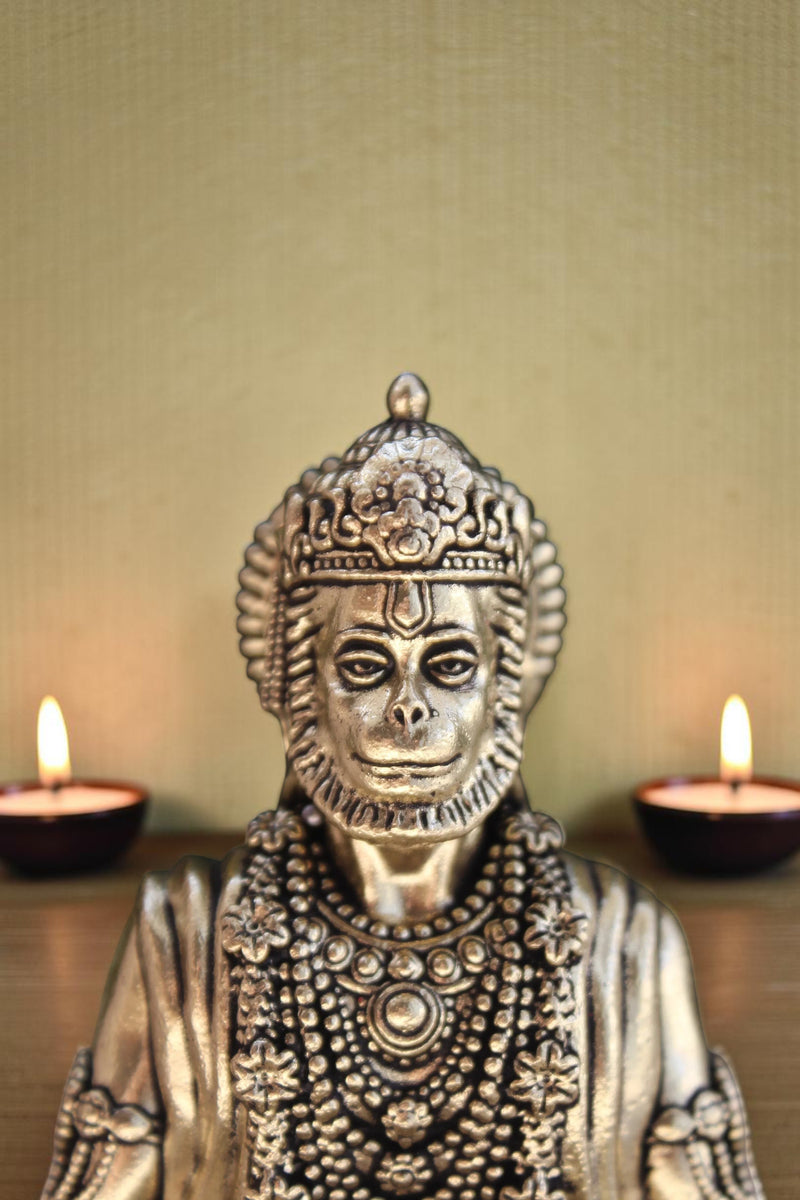 Rigvedaa brass idol of Lord Hanuman meditating in Ram Sadhna posture, adorned with intricate jewelry. Golden finish.