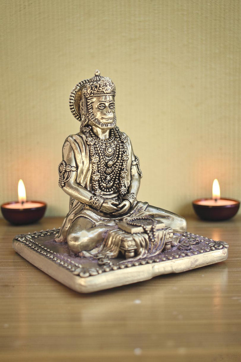 Rigvedaa brass idol of Lord Hanuman meditating in Ram Sadhna posture, adorned with necklaces and a crown. Seated on a decorative base with mala.