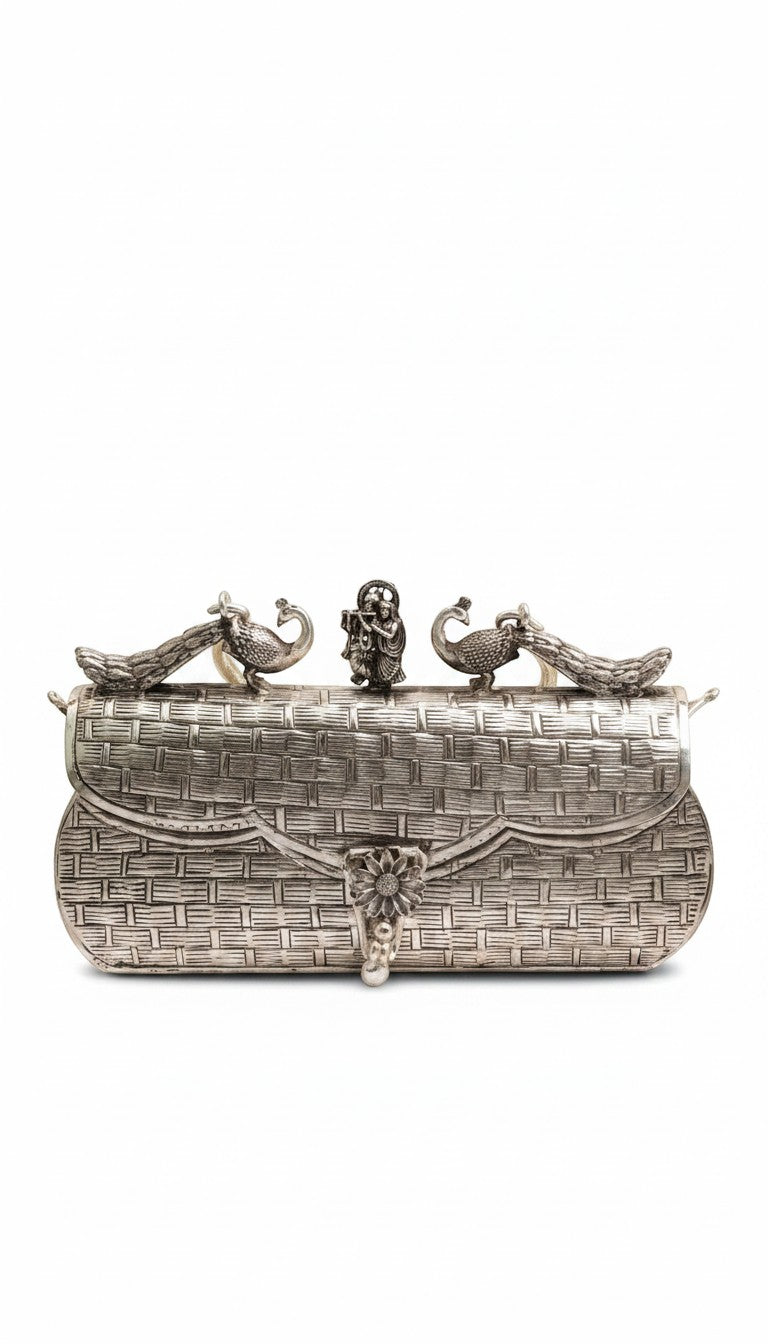 Rigvedaa™ Leela silver plated brass clutch with intricate carvings, peacock details, and a central floral clasp.