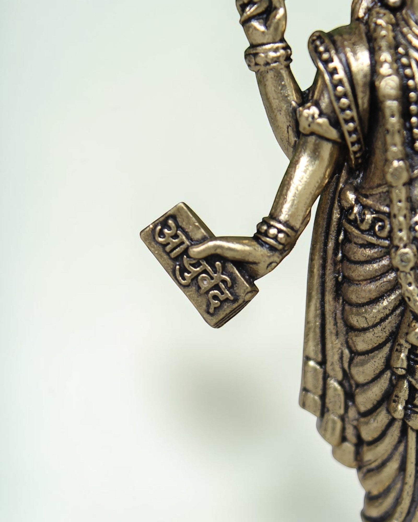 Rigvedaa Lord Dhanvantri brass idol, God of Ayurveda, holding a sacred text. Traditional detailing.