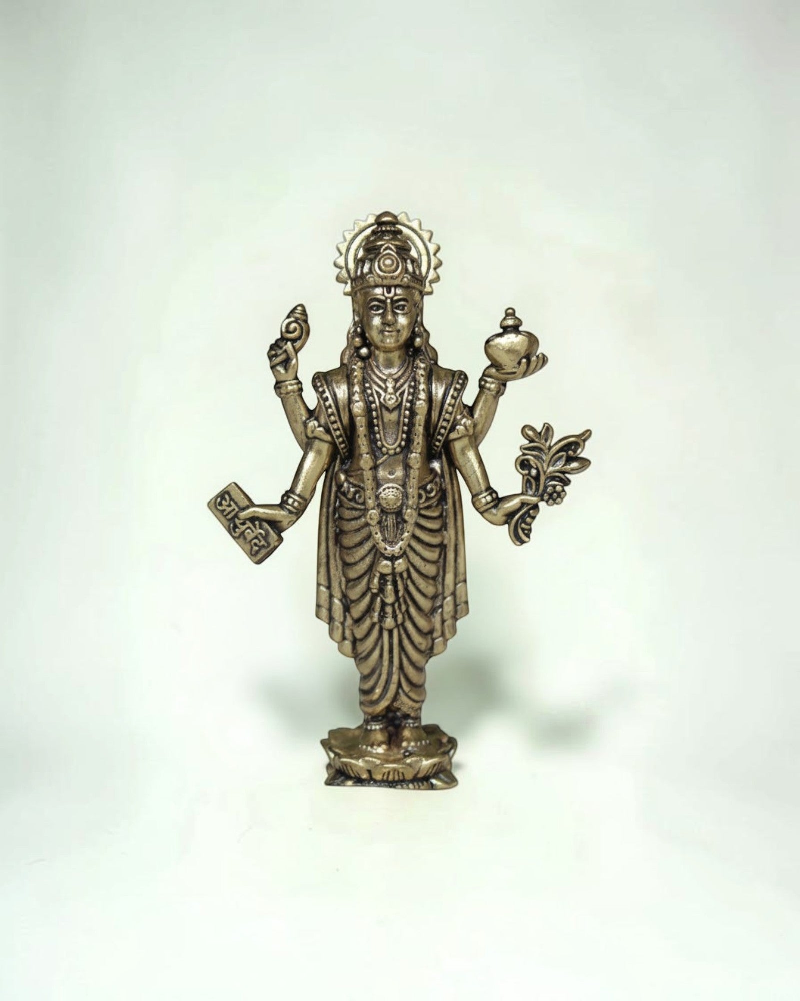 Rigvedaa™ Lord Dhanvantri brass idol, God of Ayurveda, holding a pot and herbs for health and healing.