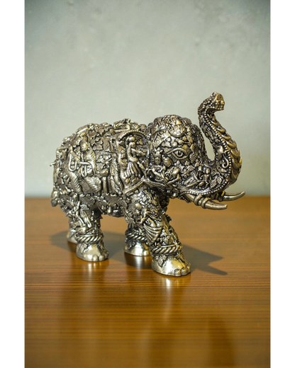 Rigvedaa brass elephant statue with intricate Radha Krishna murals, golden finish, detailed craftsmanship, ideal for puja and decor.