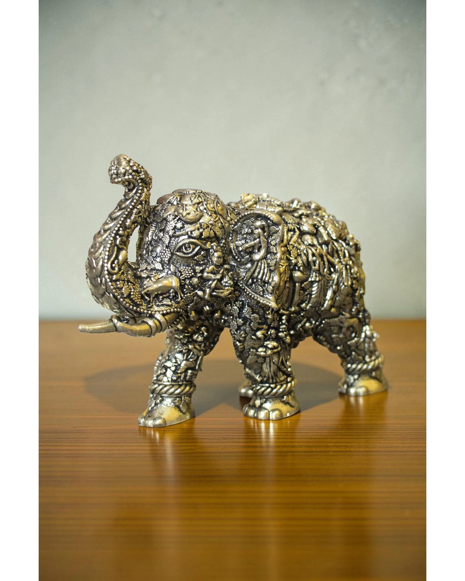Rigvedaa brass elephant statue with intricate Radha Krishna murals, golden finish, detailed craftsmanship for puja and decor.