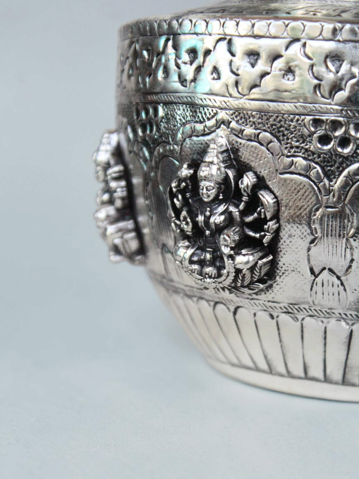 Rigvedaa™ 999 silver plated brass Ashta Lakshmi kalash featuring intricate embossed deity motifs and floral details.