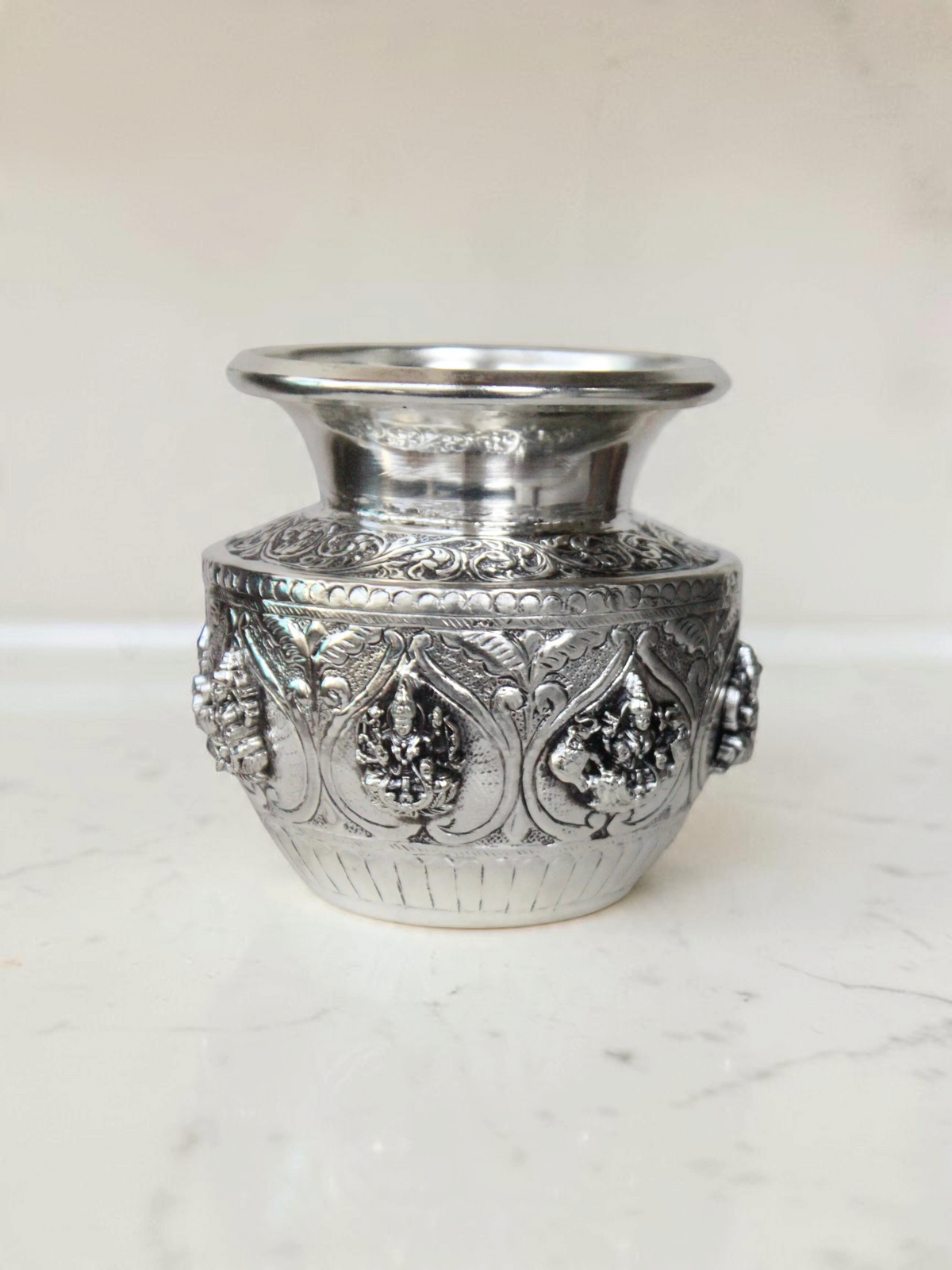 Rigvedaa™ 999 silver plated brass Ashta Lakshmi Kalash with intricate embossed floral and deity relief designs.