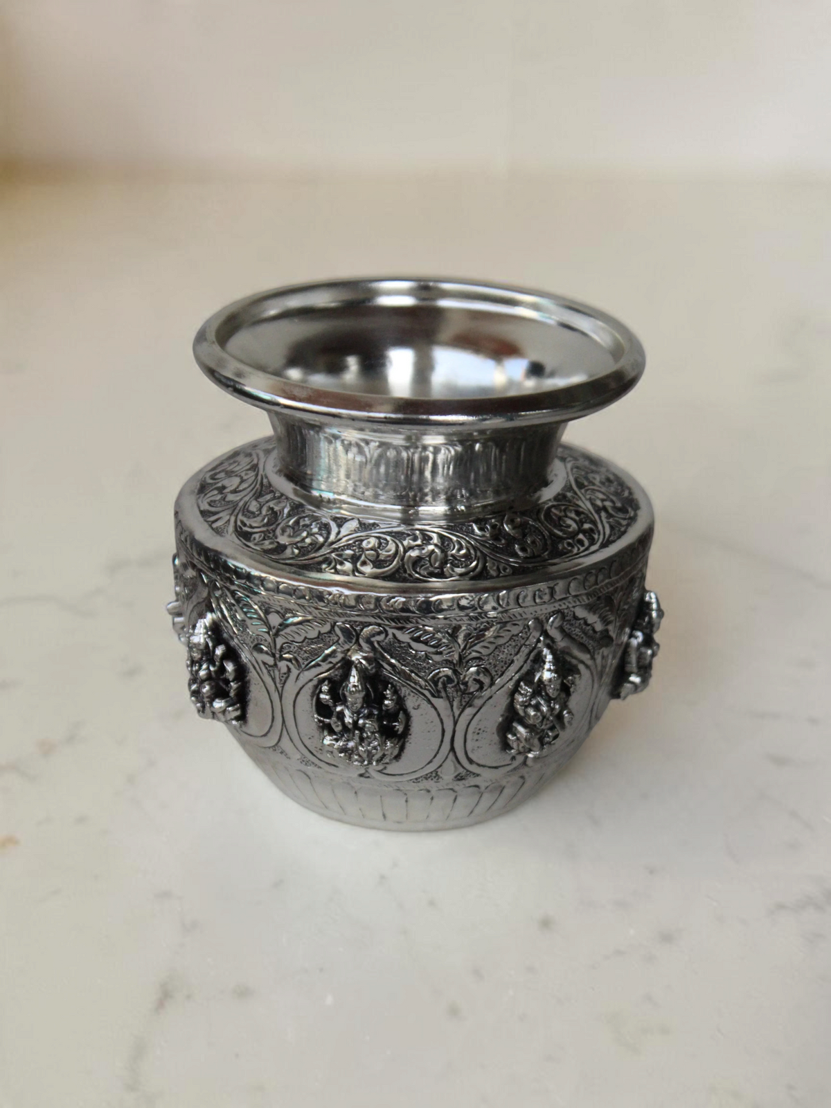Rigvedaa™ 999 silver plated brass Ashta Lakshmi Kalash with intricate embossed floral and deity relief designs.