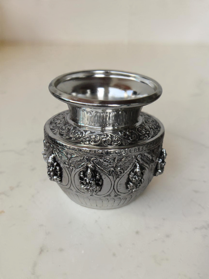 Rigvedaa™ 999 silver plated brass Ashta Lakshmi Kalash with intricate embossed floral and deity relief designs.
