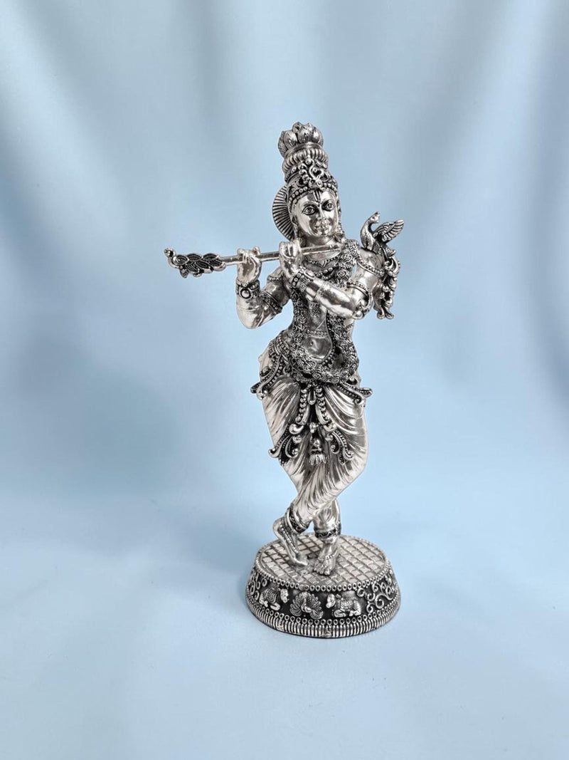 Rigvedaa™ 18-inch silver-plated brass Krishna statue in Tribhanga posture playing a flute with intricate detailing.