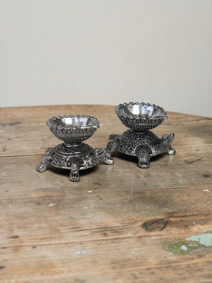 Rigvedaa™ silver-toned turtle shaped diya oil lamp holders with intricate traditional metal detailing