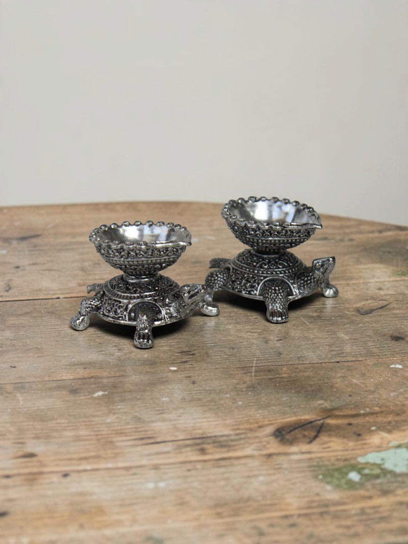 Rigvedaa™ silver-toned turtle shaped diya oil lamp holders with intricate traditional metal detailing
