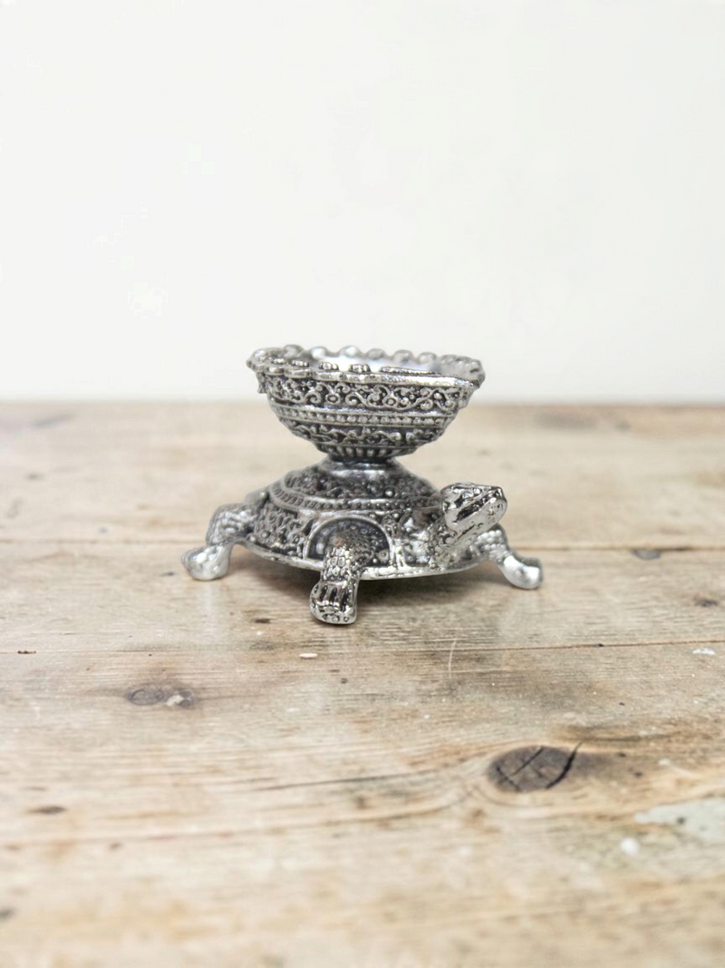 Rigvedaa™ silver-toned turtle diya oil lamp holder with intricate traditional metalwork detailing