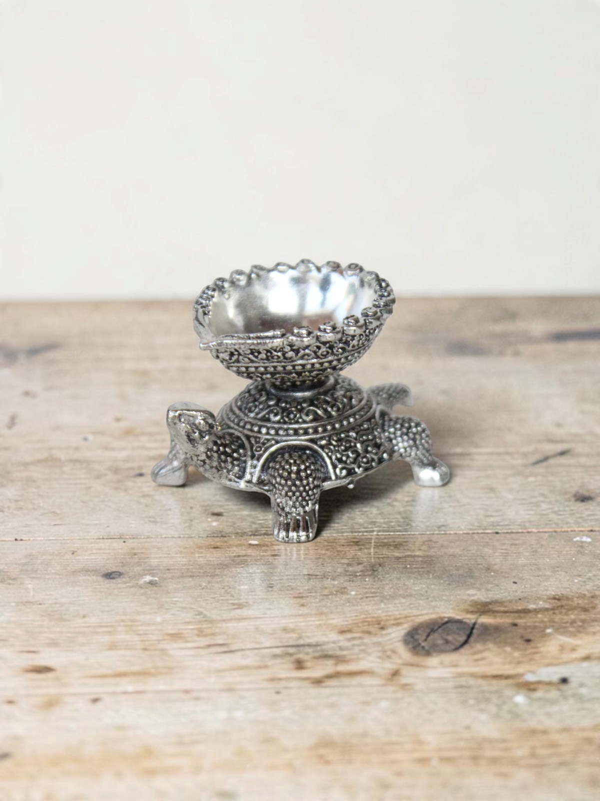 Rigvedaa™ silver-toned turtle diya oil lamp holder with intricate traditional metal detailing for home decor